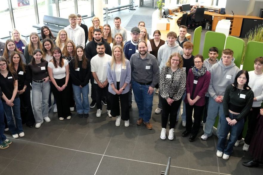 Gruppe von Menschen in einem modernen B&uuml;rogeb&auml;ude, stehend f&uuml;r ein Gruppenfoto.