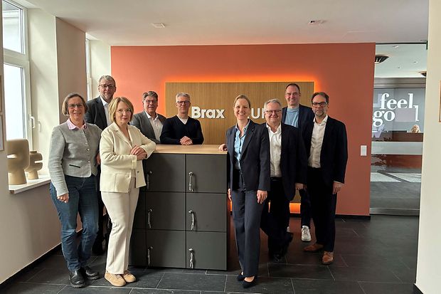 Gruppenfoto von Unternehmensvertretern vor Empfangstresen.