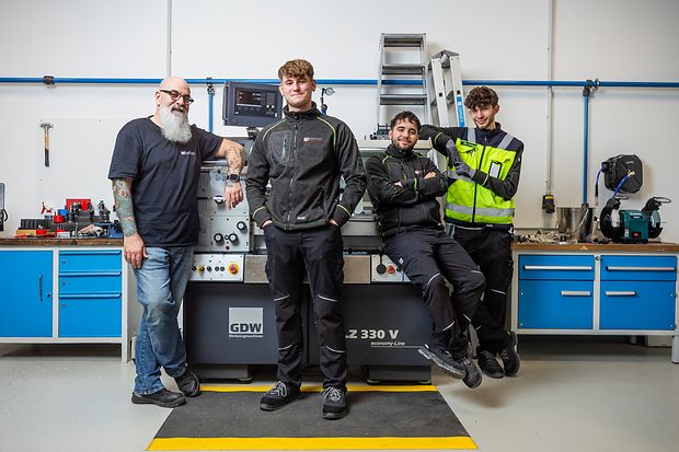 Ausbilder mit Auszubildenden in einer Werkstatt
