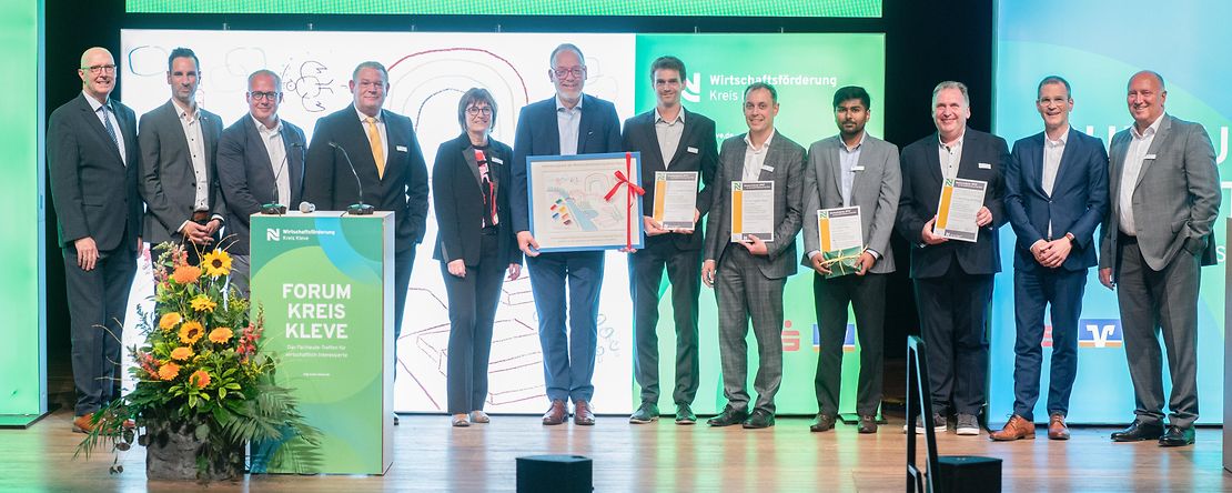 Gewinner des Hochschulpreises stehen l&auml;chelnd auf der B&uuml;hne.
