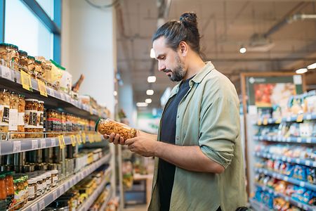 Ein Mann im Supermarkt studiert ein Etikett