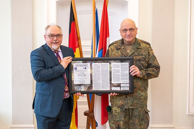 Ein Oberst der Bundeswehr &uuml;berreicht eine Partnerschaftsurkunde an den Gesch&auml;ftsbereichsleiter der IHK
