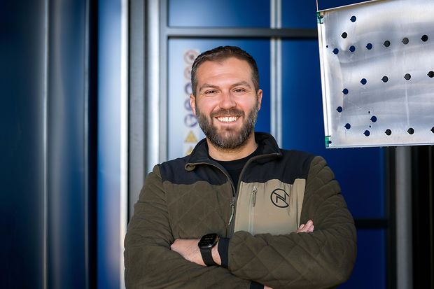 Ein Mann steht vor einer Industriehalle 