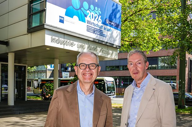 Wahlleiter und Vize-Hauptgesch&auml;ftsf&uuml;hrer vor dem Wahlbanner
