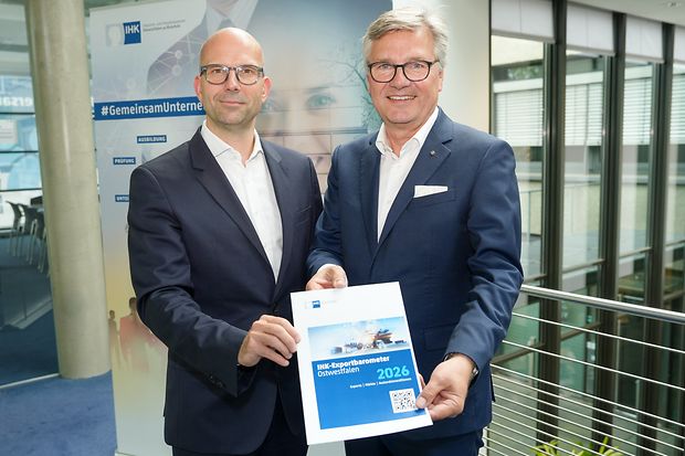 Zwei M&auml;nner pr&auml;sentieren IHK-Exportbarometer Ostwestfalen 2026