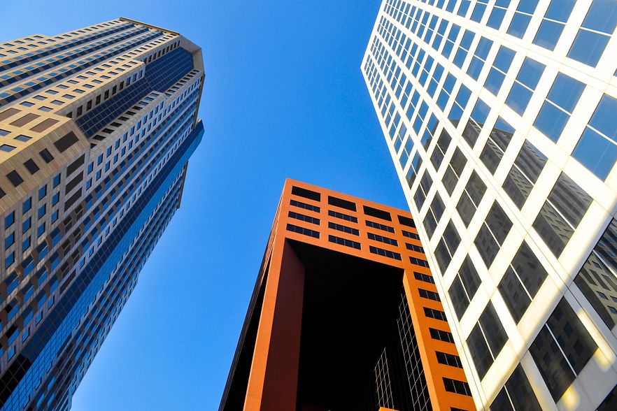 Blick von unten auf mehrere moderne Hochh&auml;user in den USA.