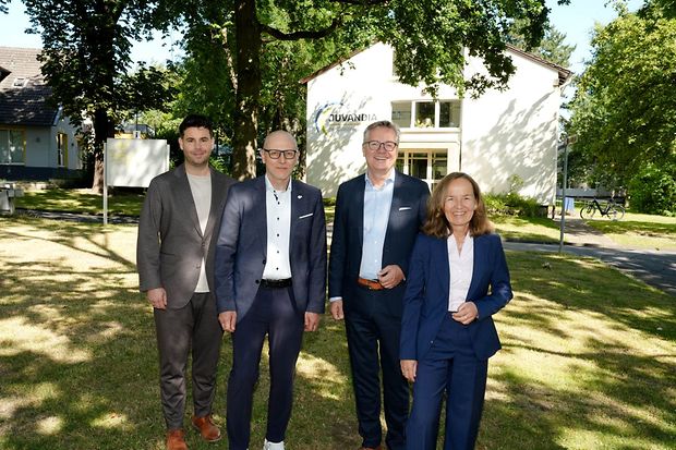 Vier Personen vor einem Geb&auml;ude bei einem Unternehmensbesuch