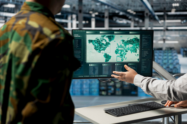 Nahaufnahme von Milit&auml;rexperten, die in einem Rechenzentrum auf einer digitalen Karte auf relevante Regionen zeigen.